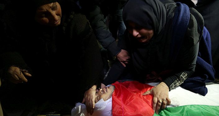 إحدى أقارب كرم فياض وهي تنظر إلى جثمانه خلال جنازته في جنوب قطاع غزة