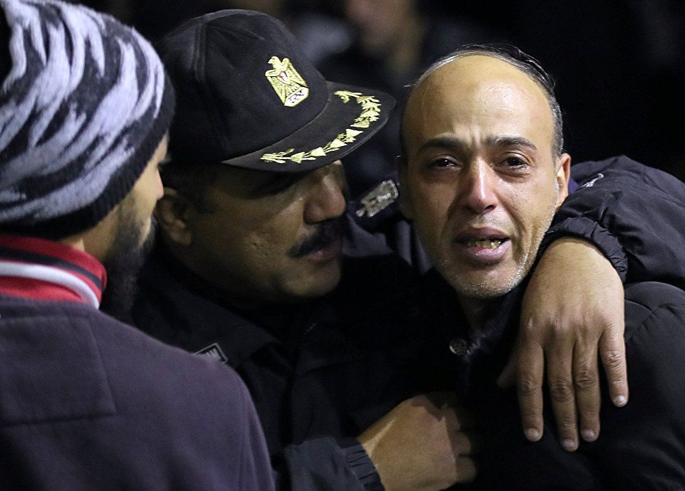 شرطي مصري يواسي مواطنا في موقع العملية الإرهابية في محيط الجامع الأزهر