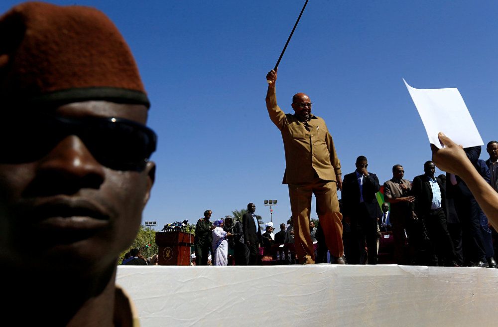الرئيس السوداني عمر البشير ملوحا إلى أنصاره خلال مسيرة في الساحة الخضراء في الخرطوم