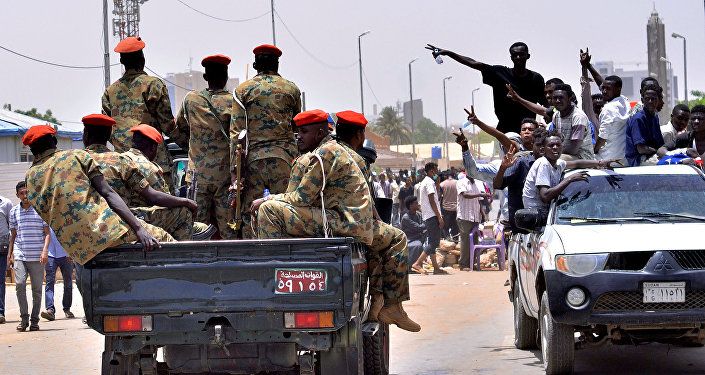 مظاهرات سودانية تحتفل وهي تسير باتجاه مركبة عسكرية بالقرب من وزارة الدفاع في الخرطوم