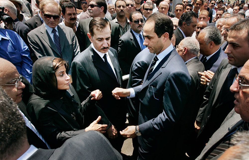جمال مبارك نجل الرئيس المصري حسني مبارك (يمين الوسط) يمد يده إلى منى عبد الناصر (يسار الوسط) أرملة أشرف مروان في جنازة زوجها في القاهرة