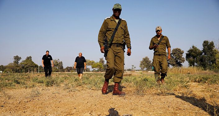 عساكر الجيش الإسرائيلي يتفحصون أماكن سقوط قذائف على الحدود الإسرائيلية مع غزة، السبت 14 يوليو/تموز 2018