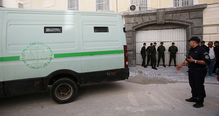 ضباط الشرطة بالقرب من سيارة نقل السجناء عند بوابة المحكمة بعد أن تم نقل أحد رجال الأعمال المشتبه بهم في الجزائر العاصمة