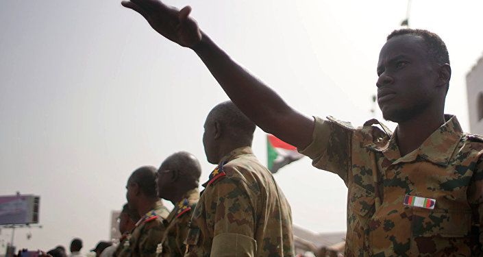 جنود في السودان بالقرب من متظاهرين أثناء مظاهرة تطالب بتنحي عمر البشير