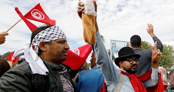 رجل يحمل الخبز أثناء احتجاج ضد رفض الحكومة رفع الأجور في تونس