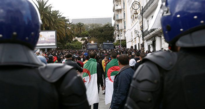 ضباط الشرطة يقفون في أثناء احتجاج على تعيين الرئيس المؤقت عبد القادر بن صالح في الجزائر العاصمة