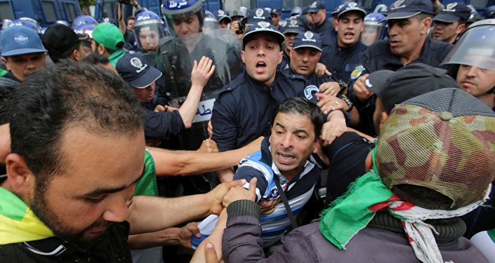 يواجه المتظاهرون وضباط الشرطة بعضهم البعض خلال احتجاج للمطالبة بتأجيل الانتخابات الرئاسية في الجزائر العاصمة