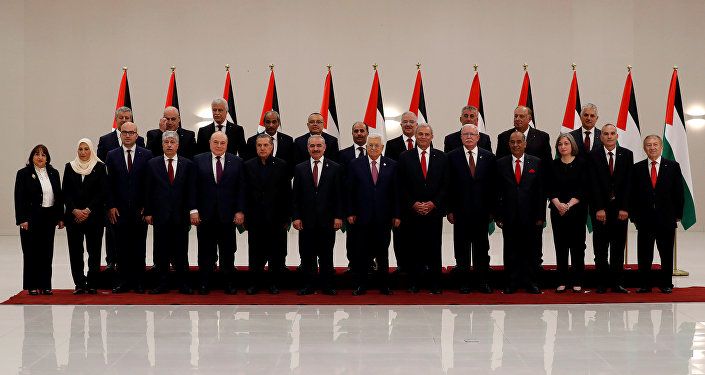 الرئيس الفلسطيني محمود عباس مع أعضاء الحكومة الفلسطينية الجدد أثناء أداءهم اليمين الدستورية