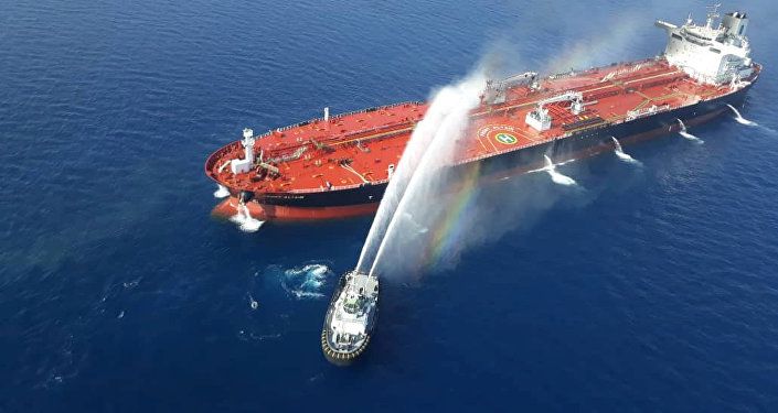 قارب بحرية إيرانية يحاول إيقاف النيران المشتعلة في ناقلة النفط بعد أن تعرضت للهجوم في خليج عمان، 13 يونيو/حزيران 2019