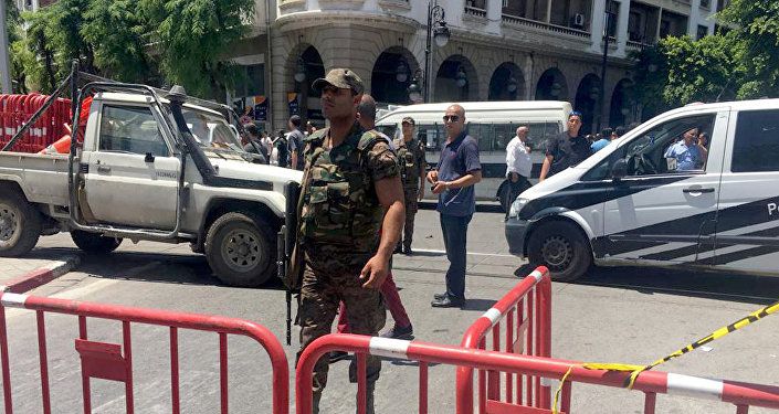 أحد أفراد قوات الأمن يقوم بتأمين موقع انفجار في شارع شارل ديغول بوسط تونس