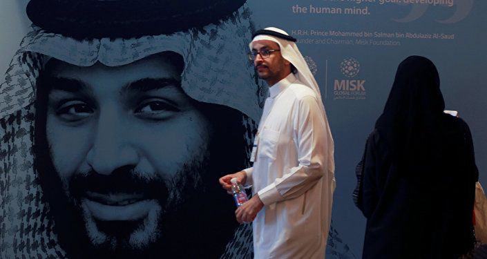 أحد المشاركين يسير بجوار صورة ولي العهد السعودي الأمير محمد بن سلمان خلال منتدى مسك العالمي في الرياض