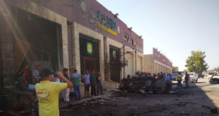 أشخاص يتجمعون في الموقع الذي انفجرت فيه سيارة مفخخة في بنغازي