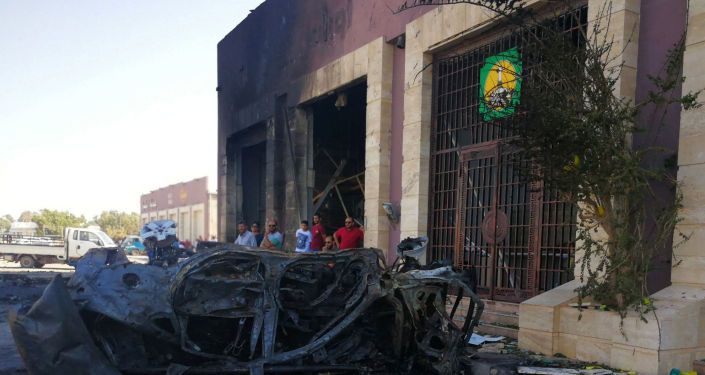 أشخاص يتجمعون في الموقع الذي انفجرت فيه سيارة مفخخة في بنغازي