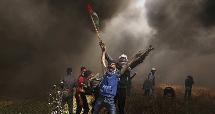 صورة العام لـ2018: متظاهرون فلسطينيون يصرخون خلال مواجهات مع القوات الإسرائيلية في مظاهرة مطالبين بحق العودة إلى وطنهم على الحدود بين إسرائيل وشرق مدينة غزة