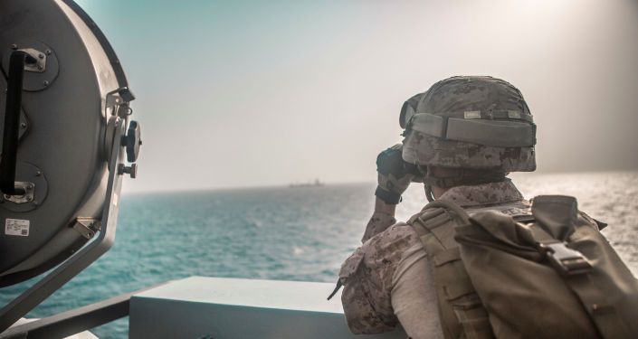جندي من مشاة البحرية الأمريكية يراقب طائرة إيرانية هجومية من سفينة حربية أمريكية جون مورثا خلال مضيق هرمز في بحر العرب قبالة عُمان، 18 يوليو/ تموز 2019