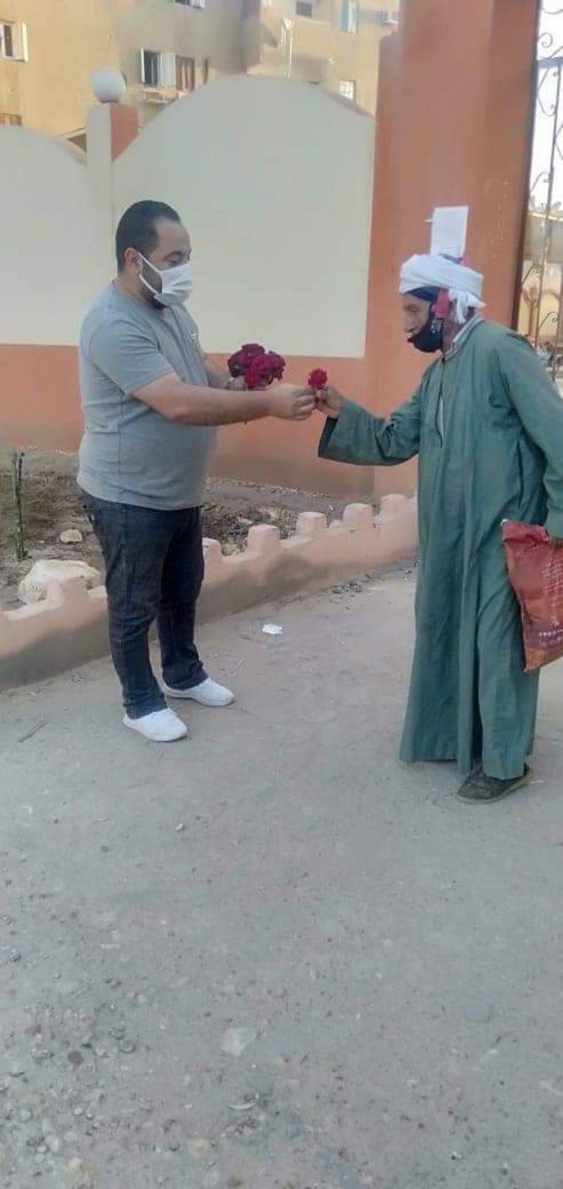 شاهد من مصر.. مسيحي يقف أمام المسجد ليوزع الورود على المصلين
