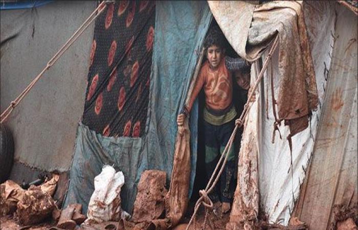 هربا من البرد.. سكان مخيمات إدلب يشعلون النار في أغراضهم