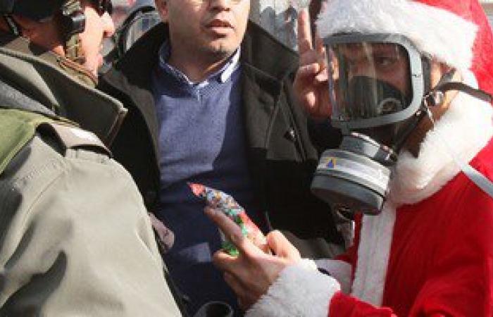 بالصور.. فلسطينيون بملابس بابا نويل يشتبكون مع الجيش الاسرائيلى فى الضفة الغربية