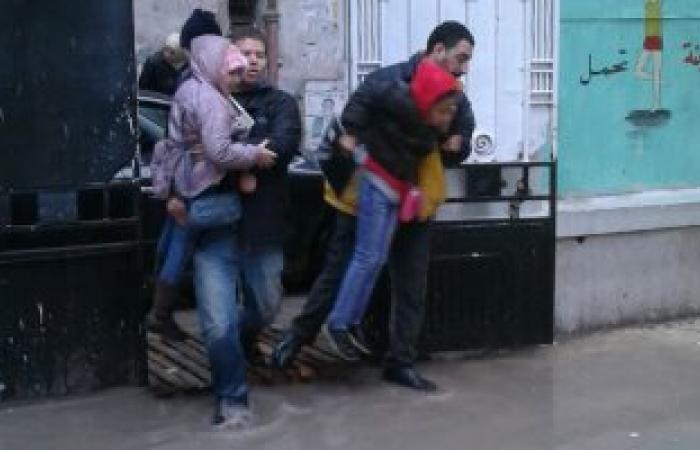 بالصور.. أولياء الأمور بالإسكندرية يحملون أبنائهم لدخول المدارس بسبب غرقها بالأمطار