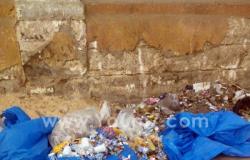 بالصور.. مواطن ينافس القطط فى البحث عن الطعام بين أكوام القمامة بالمنيا